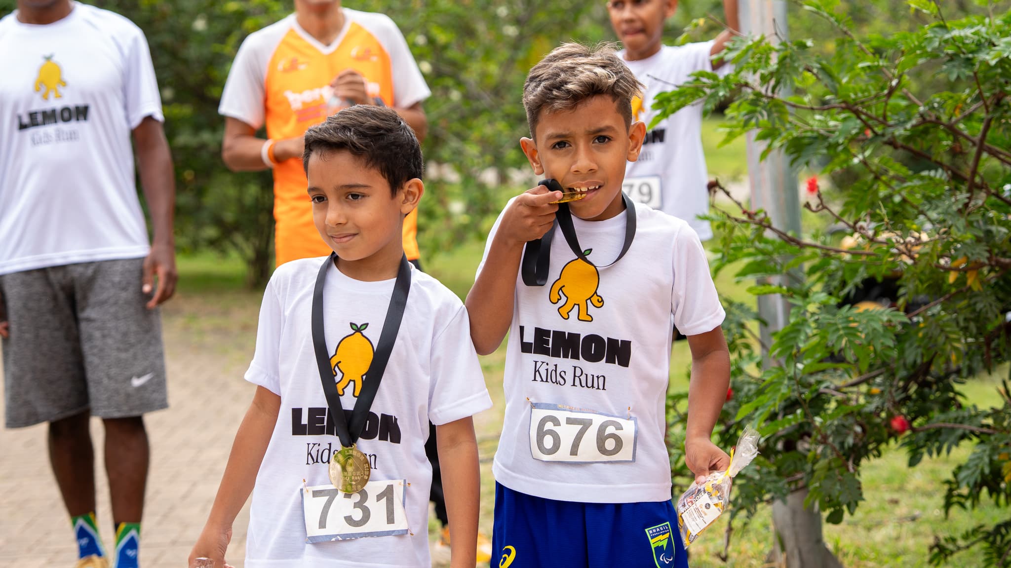Menino comemorando com a medalha nos dentes